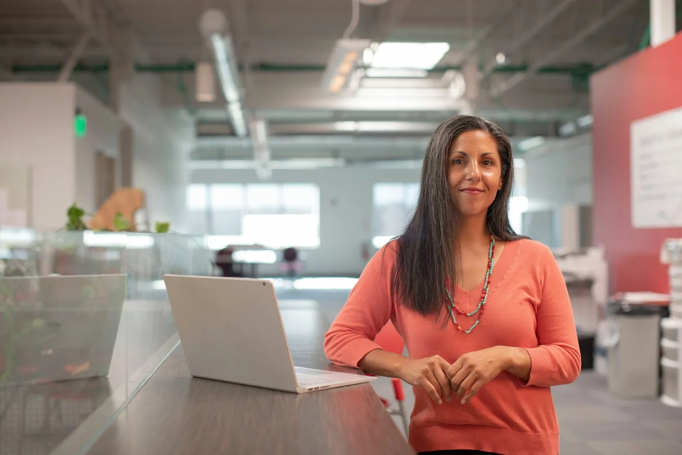 Gestora de marketing no escritório, ao lado do notebook